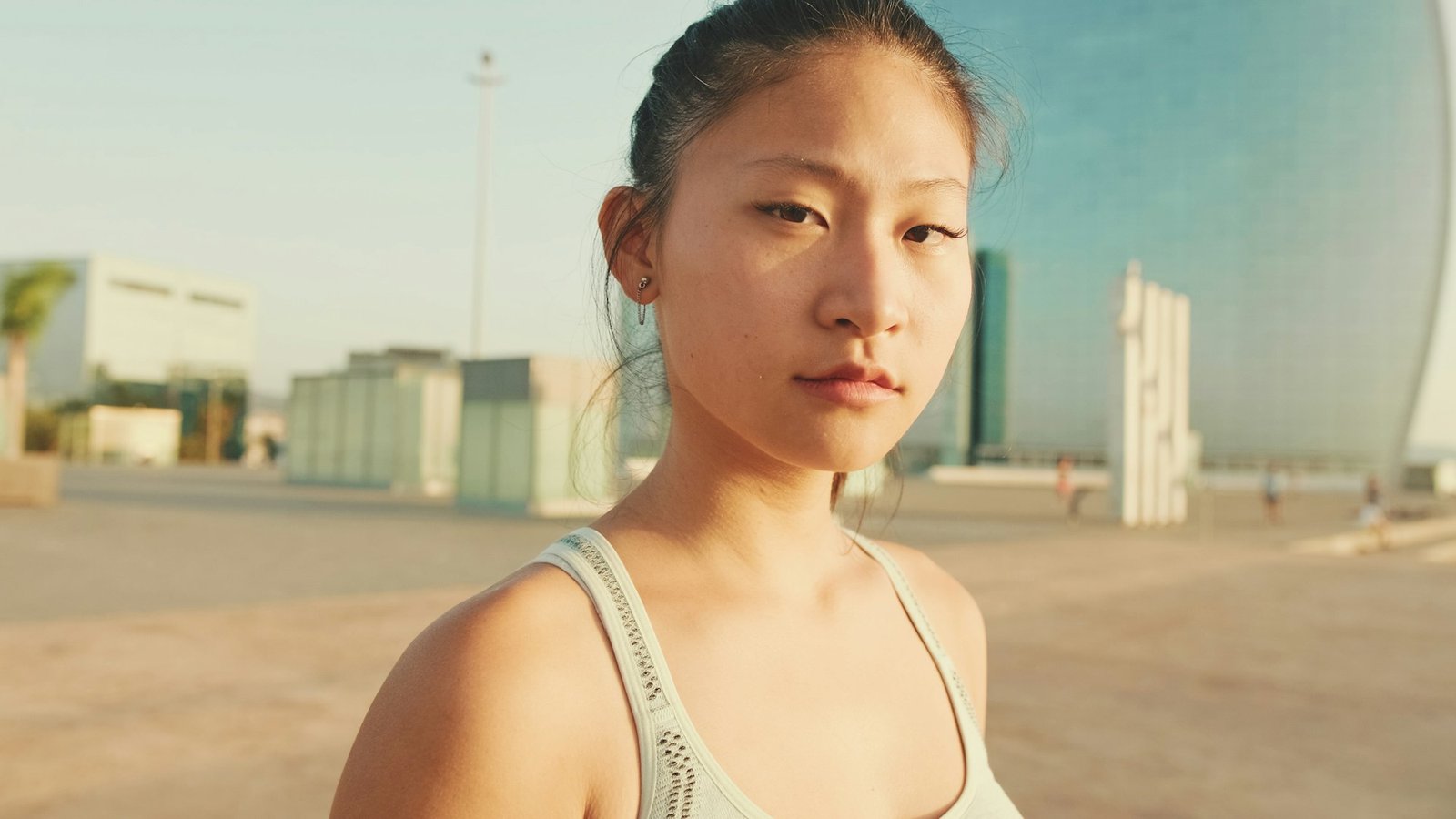 Close up, asian girl in sports top looks at the camera