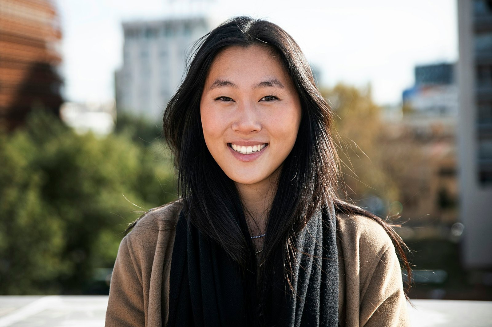 portrait of a happy young woman outdoor - Close up of a smiling asian girl in the city